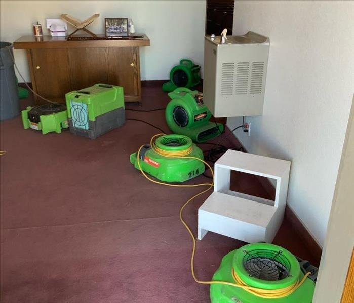 Room with red carpet and green air movers.