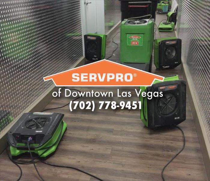 Multiple green SERVPRO air movers on the ground.