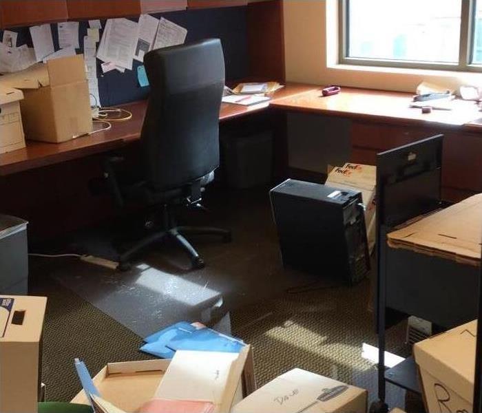 An office, cardboard boxes and folders on wet floor.
